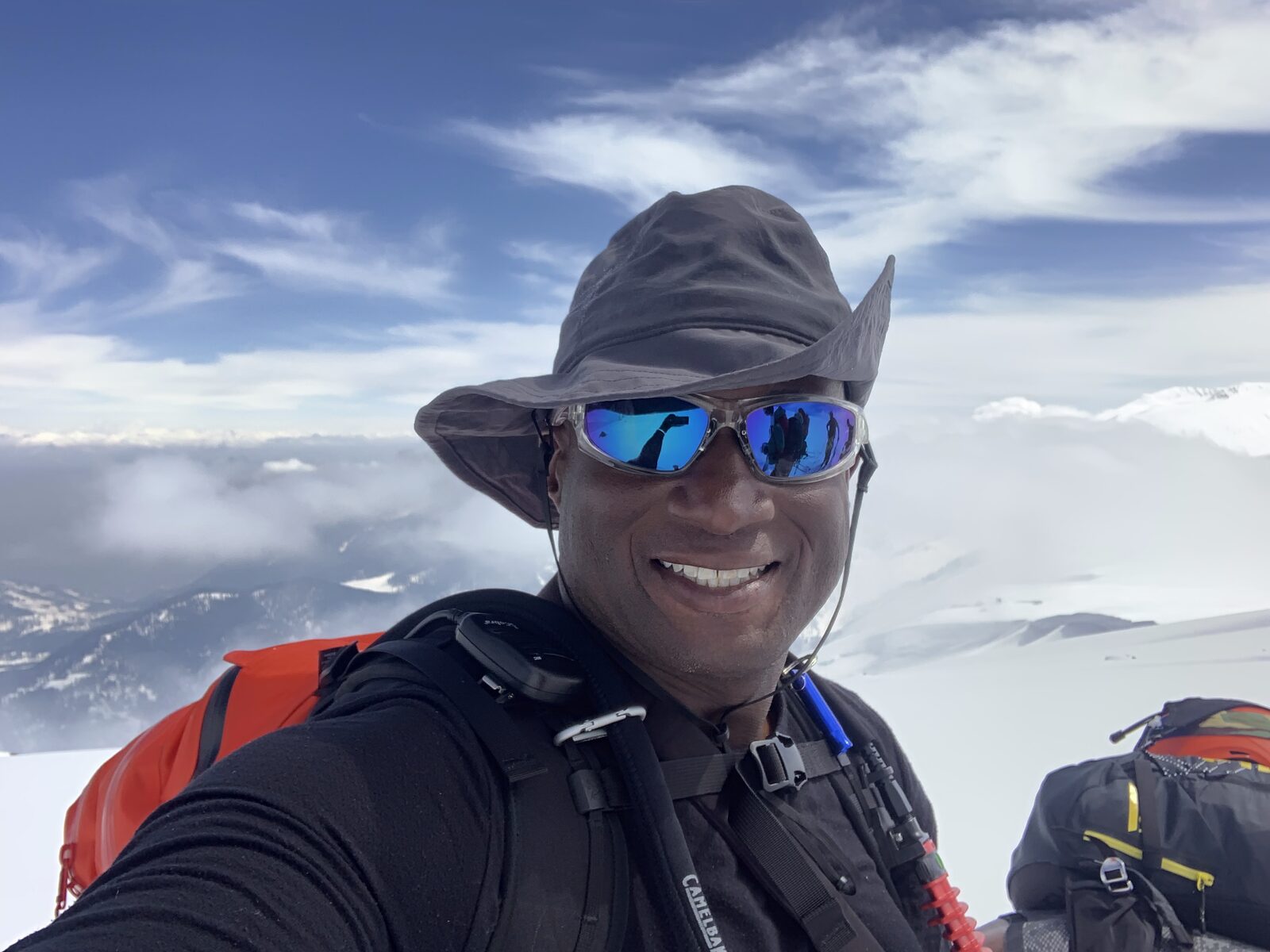 Bennett Wyche smiling on a snowy mountain summit